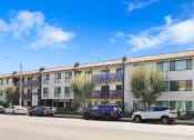 Thumbnail 64 of 64 - an apartment building on the side of a street with parked cars
