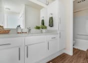 Thumbnail 8 of 64 - a white bathroom with a large mirror and white cabinets