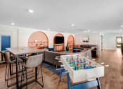 Thumbnail 56 of 64 - a living room with a table and chairs and a game table in the middle