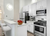 Thumbnail 1 of 61 - an apartment kitchen with stainless steel appliances and white cabinets
