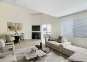 Thumbnail 2 of 61 - a living room with a white couch and a table with chairs