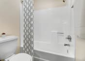 Thumbnail 6 of 61 - a bathroom with a toilet and a tub and a shower curtain