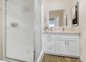 Thumbnail 9 of 52 - a bathroom with a shower and a sink and a mirror