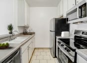 Thumbnail 1 of 102 - an all white kitchen with stainless steel appliances and a sink