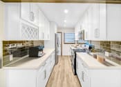 Thumbnail 1 of 17 - a large kitchen with white cabinets and stainless steel appliances