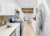 Thumbnail 2 of 17 - a white kitchen with stainless steel appliances and white cabinets