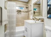Thumbnail 6 of 17 - a small bathroom with a shower and a sink and a mirror