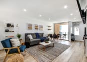 Thumbnail 18 of 29 - Furnished 1 Bedroom Suite, living room with cozy fireplace, wood inspired floors throughout unit