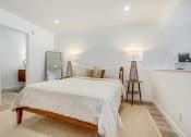 Thumbnail 20 of 29 - Sleeping area with recessed lights, plank flooring, bathroom on the left