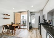 Thumbnail 19 of 29 - Furnished open kitchen with black quartz countertops, stainless steel appliances, recessed lights