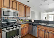 Thumbnail 13 of 88 - a kitchen with stainless steel appliances and wooden cabinets