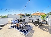 Thumbnail 87 of 88 - a patio with chairs and tables and umbrellas