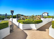 Thumbnail 86 of 88 - a view of a garden with hedges and a white fence and a blue sky