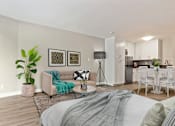 Thumbnail 24 of 76 - Sleeping and living area of a studio unit with wood-inspired floors throughout, stainless steel kitchen appliances