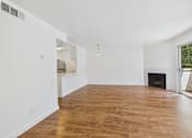 Thumbnail 49 of 60 - A large empty room with wooden floors and white walls.