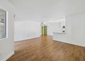 Thumbnail 32 of 60 - A room with wooden floors and white walls.