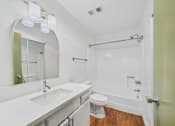 Thumbnail 33 of 60 - A white bathroom with a toilet, sink, and mirror.