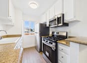 Thumbnail 34 of 60 - A kitchen with a black stove and white cabinets.