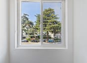 Thumbnail 41 of 60 - A white window with a view of a street with cars and trees.