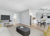 Thumbnail 4 of 18 - A living room with a white couch and a grey ottoman.