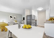 Thumbnail 3 of 18 - A kitchen with a table and chairs and a bowl of lemons on the table.