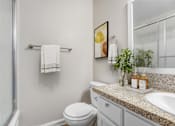 Thumbnail 7 of 18 - A white toilet sits next to a sink in a bathroom.