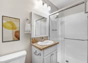 Thumbnail 8 of 18 - A bathroom with a white tub, sink, and shower.