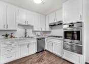 Thumbnail 2 of 67 - A kitchen with white cabinets and stainless steel appliances.