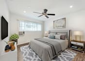 Thumbnail 6 of 67 - A bedroom with a large bed and a ceiling fan.