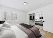 Thumbnail 9 of 38 - A bedroom with a bed, a mirror, and a wardrobe.