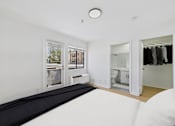 Thumbnail 10 of 38 - A white room with a black mattress and a window.