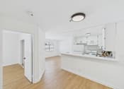 Thumbnail 40 of 46 - A white kitchen with a white fridge and cupboards.