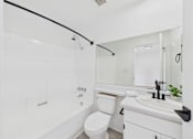 Thumbnail 46 of 46 - A white bathroom with a toilet, sink, and shower.