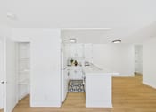 Thumbnail 39 of 46 - A kitchen with white cabinets and a white island.
