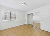 Thumbnail 43 of 46 - A room with a wooden floor and a window with blinds.