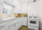Thumbnail 6 of 35 - a white kitchen with white appliances and white cabinets