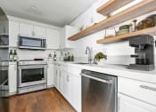 Thumbnail 1 of 86 - a kitchen with white cabinets and stainless steel appliances