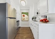 Thumbnail 15 of 36 - A kitchen with a black refrigerator and white cabinets.