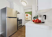 Thumbnail 14 of 36 - A modern kitchen with a stainless steel refrigerator and a white countertop.