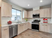 Thumbnail 1 of 12 - a kitchen with wooden cabinets and stainless steel appliances
