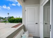 Thumbnail 10 of 12 - a balcony with a white door and a white couch with pillows
