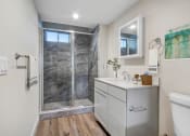 Thumbnail 12 of 12 - a bathroom with a sink and a shower with a glass door