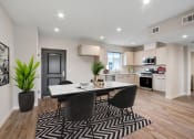 Thumbnail 4 of 12 - a dining area with a table and chairs and a kitchen in the background