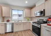Thumbnail 2 of 12 - a kitchen with light wood cabinets and stainless steel appliances