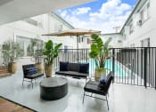 Thumbnail 17 of 17 - a patio with chairs and a table and a pool in the background