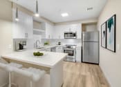 Thumbnail 6 of 39 - the preserve at ballantyne commons apartment kitchen with island and stainless steel appliances