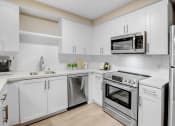 Thumbnail 1 of 39 - a white kitchen with stainless steel appliances and white cabinets