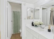 Thumbnail 20 of 50 - A white bathroom with a toilet, sink, and mirror.