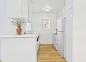 Thumbnail 21 of 50 - A kitchen with white appliances and a wooden floor.