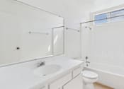 Thumbnail 32 of 50 - A white bathroom with a toilet, sink, and shower.
